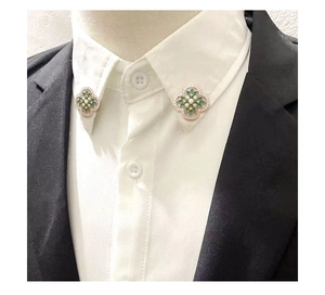 Détail de broches de col vintage en émail floral avec perles sur une chemise blanche