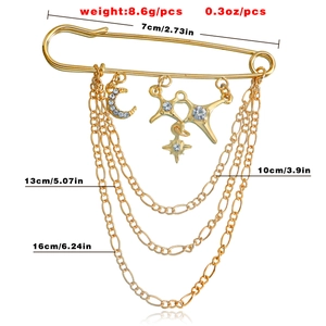 Gold safety pin brooch with layered chains and sparkling star and moon charms