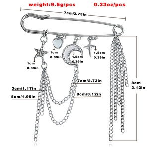 Detailed view of silver star and moon charms with layered chain tassels on a pin brooch
