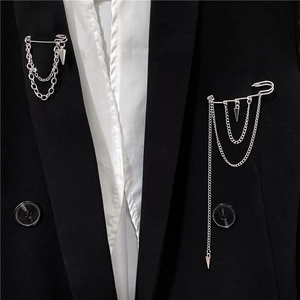 Silver punk chain brooch with metallic spikes on a black suit lapel for men and women