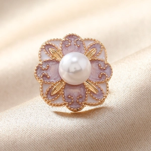 Broche fleur vintage avec perle blanche sur fond élégant en satin doré pour femmes