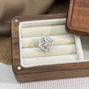 Gros plan d'une broche en forme d'étoile argentée avec strass dans un coffret en bois