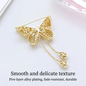 Elegant gold-tone hollow butterfly brooch with pearl tassels and layered alloy plating