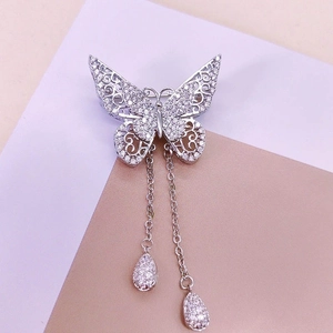 Silver butterfly brooch with hollowed wings, sparkling rhinestones and pearl tassels
