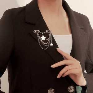 Polished silver star brooch with multi-layer tassel chains on black blazer lapel