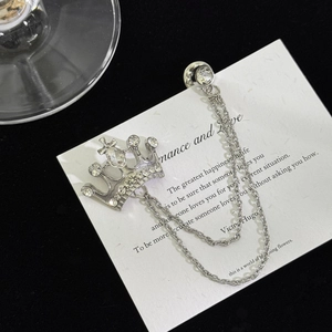 Detail of silver crown brooch with hanging double chains and sparkling rhinestones