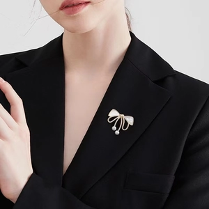 Broche élégante en forme de nœud avec incrustation de nacre et perles sur un costume