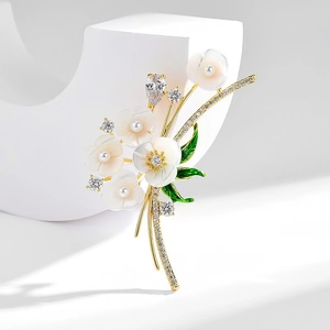 Elegant gold flower brooch with mother-of-pearl petals and sparkling zircon accents