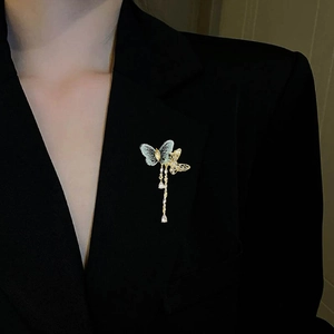 Eleganter Vintage Stoff Schmetterling Brosche mit Quasten und Strass auf schwarzem Blazer
