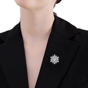 Macro detail of luxury sparkling snowflake brooch with zircons on a black suit blazer