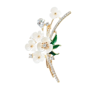 Enamel flower brooch with white petals, gold finish and rhinestones on white background