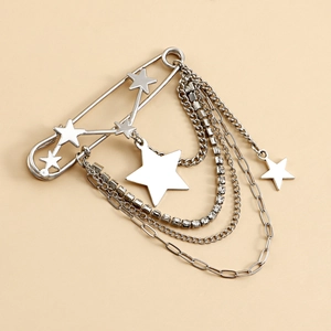 Macro shot of a silver star brooch with dangling layered chains and crystal accents