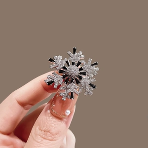 Elegant rotating snowflake brooch with silver metal, black and white sparkling crystals