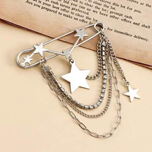 Detailed macro of silver star brooch with layered rhinestone chains and punk star charms