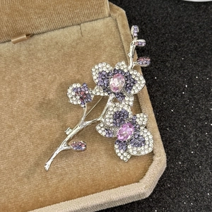 Détail de la broche orchidée sertie de zircons violets sur base en métal argenté