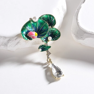 Detail of green enamel lotus brooch with pearl accents and crystal drop pendant