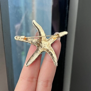 Détail de l'arrière de la broche étoile de mer vintage avec fermoir épingle de sûreté doré