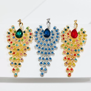 Detailed macro view of peacock brooches featuring colorful gemstones and rhinestones
