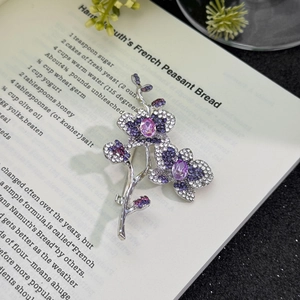 Broche élégante d'orchidée papillon violette avec cristaux sur fond de livre vintage