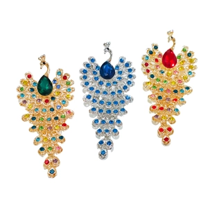 Close-up of peacock brooches in gold and silver finish with colorful rhinestones