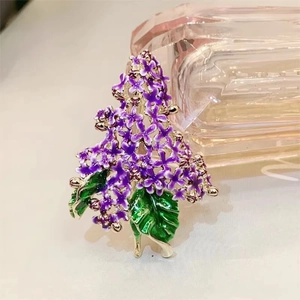 Elegant purple lilac flower enamel brooch with gold plating on pink glass backdrop