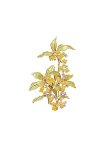 Macro shot of elegant osmanthus brooch with yellow enamel flowers and green leaves