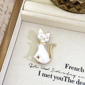 Creative enamel cat brooch with gold accents in a luxury jewelry box display