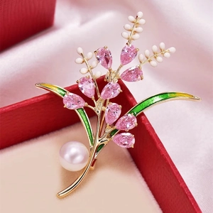 Détail de la broche épi de blé en cristal rose avec perle blanche et émail vert