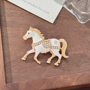Exquisite gold-plated horse brooch with white enamel and sparkling rhinestones