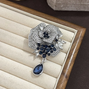 Elegant silver rose brooch with white rhinestones and deep blue crystal teardrop pendant