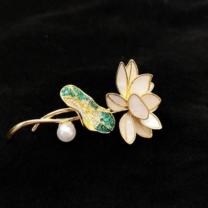 Detail einer eleganten Lotus-Brosche mit Muschel-Blüten, grünen Steinen und einer Perle
