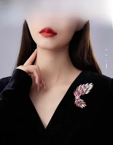 Spilla ad ali con cristalli sfumati rosa su un elegante abito in velluto nero da modella