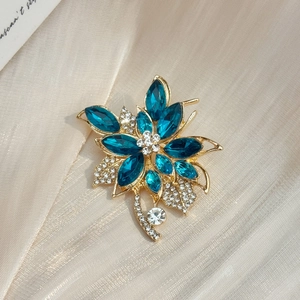 Broche fleur dorée exquise avec cristaux bleu foncé et strass micro-sertis