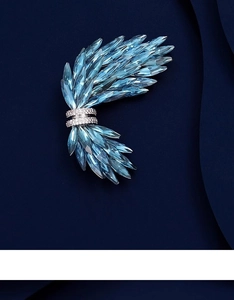 Dettaglio della spilla ad ala in cristallo con pietre azzurre e rifiniture in pavé lucido