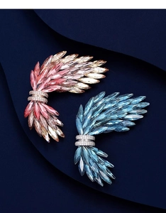 Dettaglio delle spille ad ala in cristallo con pietre taglio marquise in rosa e blu