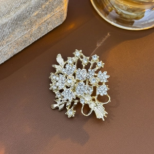 Broche luxueuse en forme de bouquet doré avec cristaux scintillants sur cuir chaud