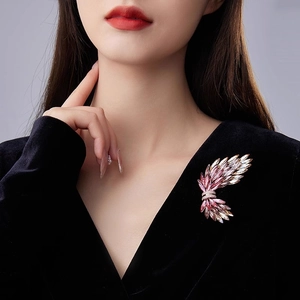 Elegante spilla a forma di ala con cristalli rosa su un abito di velluto nero