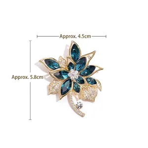 Broche fleur raffinée avec pierres bleu foncé et feuilles en cristal sur fond blanc