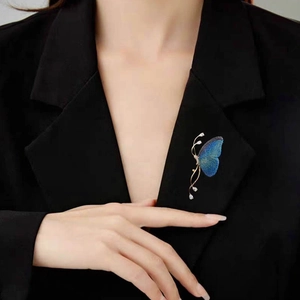 Broche papillon bleu dégradé avec cristaux sur le revers d'un costume noir chic