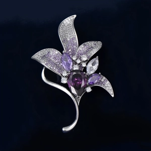 Gros plan sur la broche magnolia en argent avec cristal violet et détails en zircone