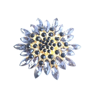 Elegant magnolia flower brooch with grey and black crystals on gold base
