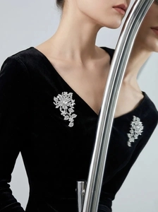 Detail of luxury flower brooch with crystals on black velvet dress, vintage style