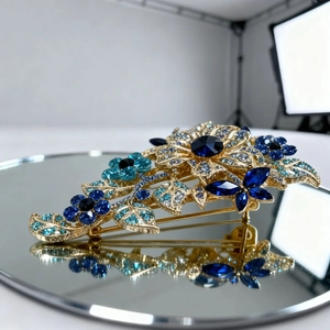 Detailed close-up of a floral crystal brooch with blue rhinestones and gold alloy finish