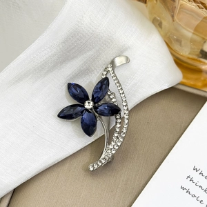 Broche fleur argentée élégante avec cristaux bleu foncé et strass brillants sur pétales