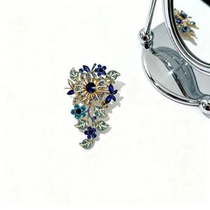 Macro detail of luxury floral brooch with blue crystals and elegant golden finish