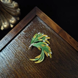 Broche élégante en émail en forme de plume aux reflets vert et or avec pierres