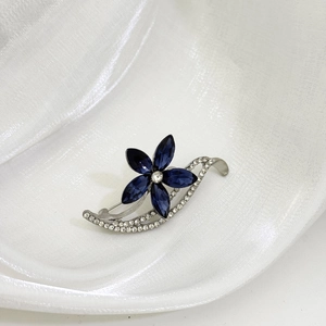 Détail de la broche fleur argentée avec pierres marquises bleu foncé et pavé de zircons