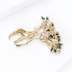 Back view of a gold giraffe brooch with green enamel accents and secure pin closure