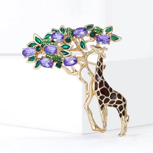 Detailed close-up of giraffe brooch with purple gemstones and green enamel tree design