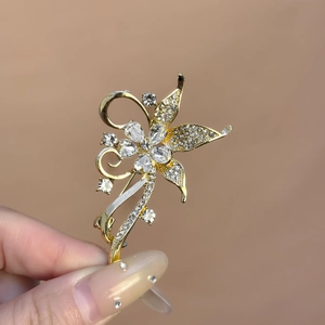 Détail de la broche florale dorée de luxe avec micro-incrustation complexe de zircons cubiques